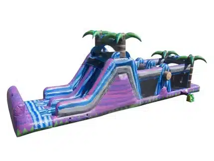 Tropical inflatable water slide with dual lanes, palm trees, and extended slip-and-slide section. Perfect for summer fun. Buy online in Canada today!