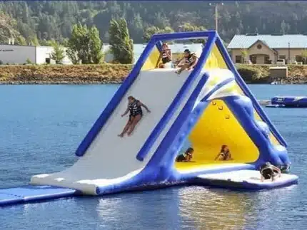 Large inflatable water slide with climbing wall and play area, perfect for lakes and summer fun. Great for group activities. Buy in Canada today!