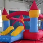 Colorful red, blue, and yellow bouncy castle with turrets, mesh sides, and a slide. Great for indoor or outdoor fun. Buy online in Canada today!