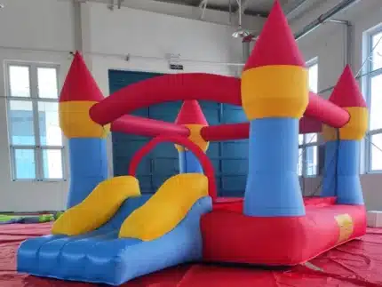 Colorful red, blue, and yellow bouncy castle with turrets, mesh sides, and a slide. Great for indoor or outdoor fun. Buy online in Canada today!