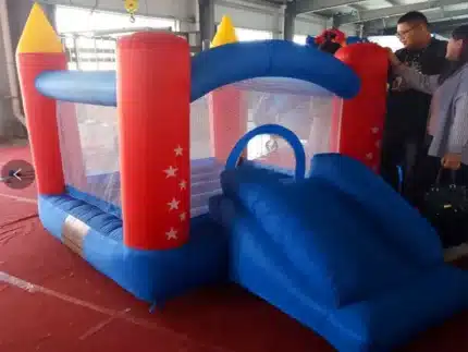 Small red and blue bouncy castle with mesh sides, star accents, and a slide. Perfect for indoor or backyard fun. Buy online in Canada today!