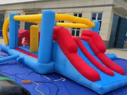 Colorful inflatable play structure with dual red slides, blue base, and yellow accents. Perfect for kids' parties. Buy online in Canada today!